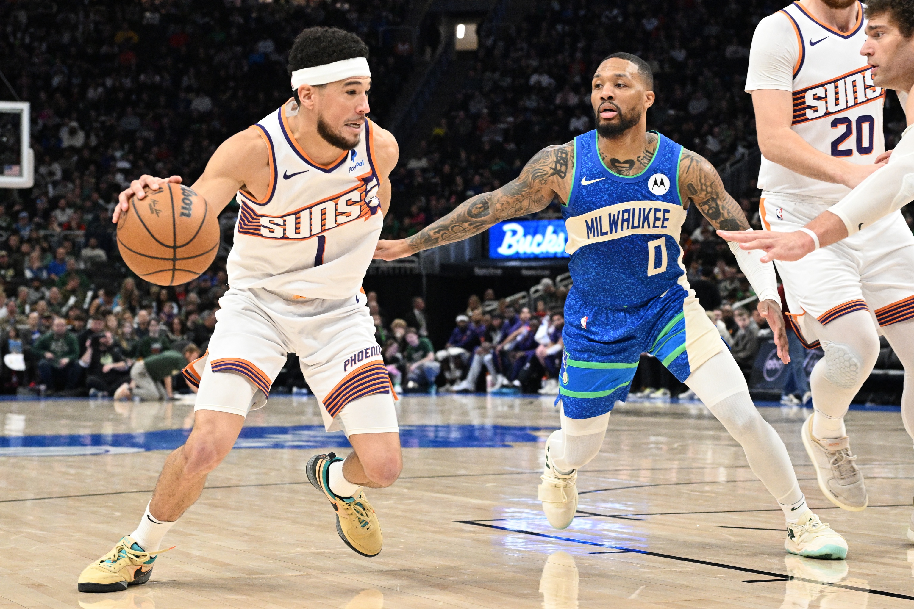 Phoenix Suns guard Devin Booker (1) drives to the basket against Milwaukee Bucks guard Damian Lillard (0) 
